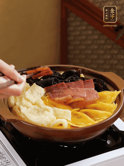 砂鍋底部鋪上娃娃菜，依次擺上肉皮、蛋餃、黑木耳、火腿